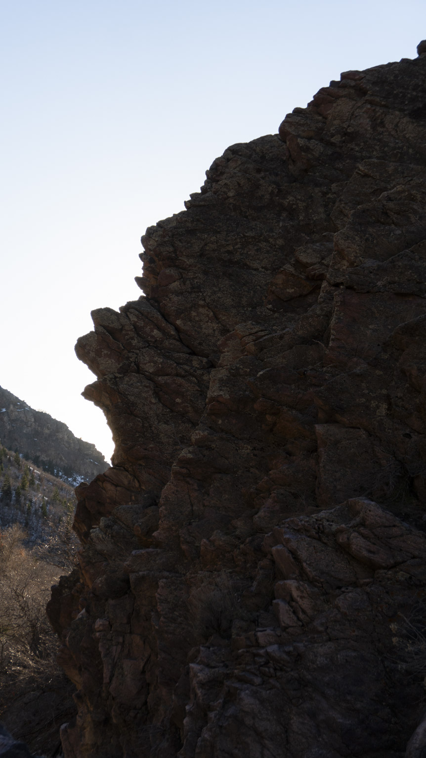 A big rocky ridge in silhouette against a bright sky